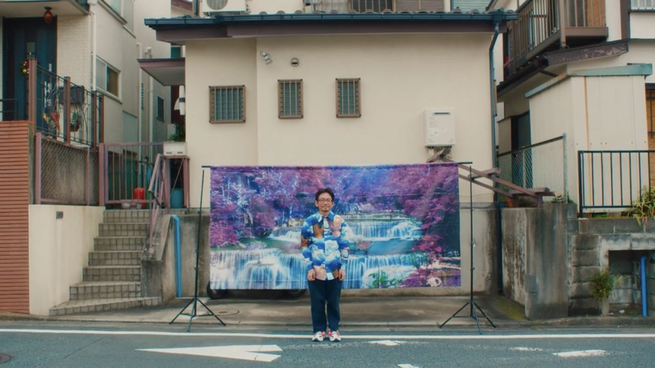 a woman standing in front of a painting on the side of a building