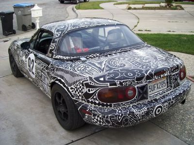 a car covered in a pattern parked on the side of the road