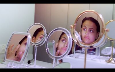 a woman looking at herself in the mirror