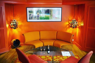 a living room with orange walls and furniture