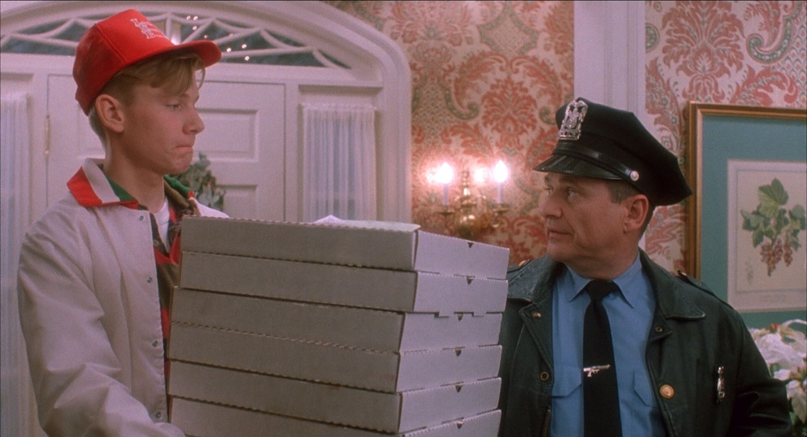 a man holding a stack of boxes next to a little boy