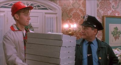 a man holding a stack of boxes next to a little boy