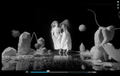 a black and white photo of two young girls standing in front of a pile of