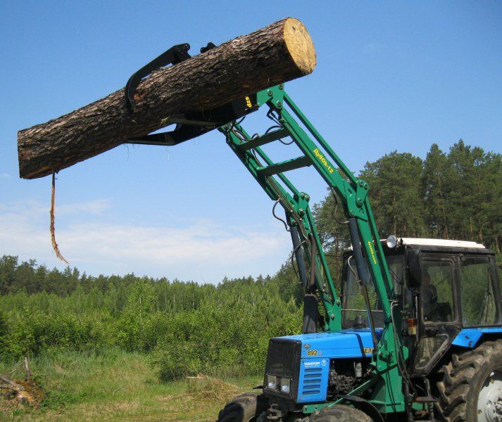 a tractor with a log on the back of it