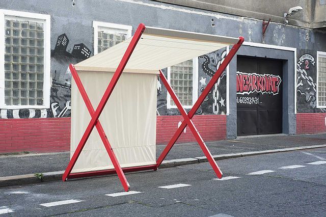 a red and white structure sitting on the side of a road