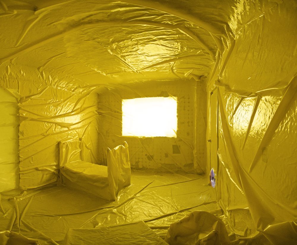 a yellow room with a bed and a window