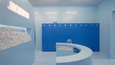 a blue bathroom with a curved counter and blue lockers