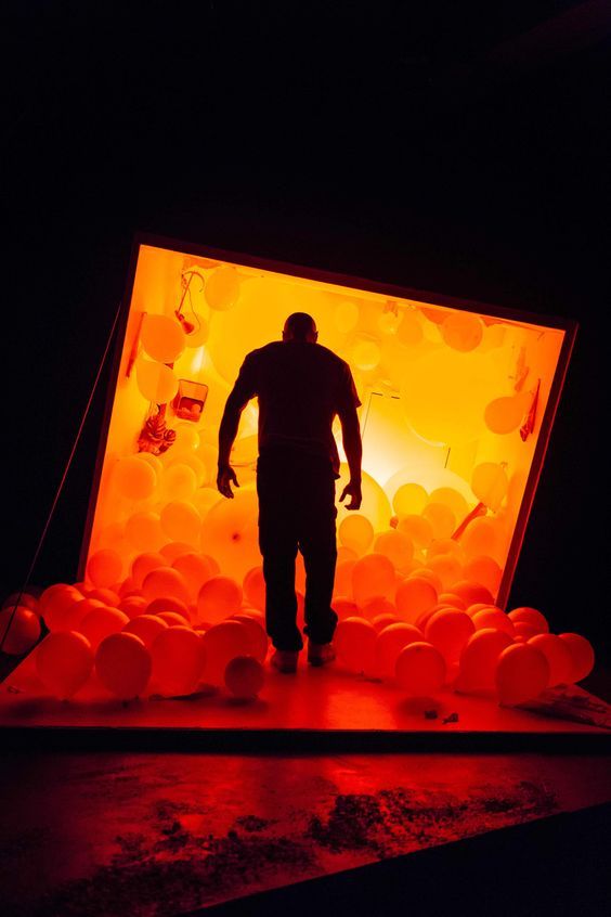 a man standing in front of a display of balloons