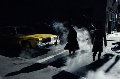 a group of people walking down a street next to a yellow car