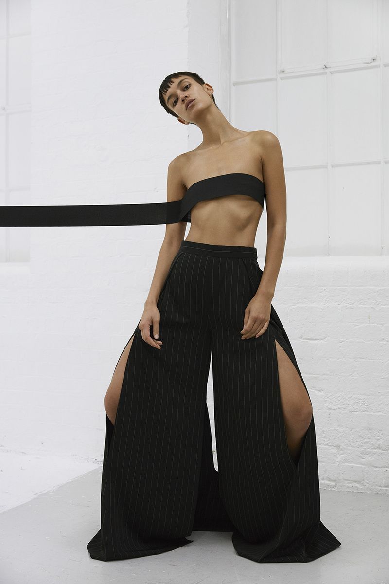 a woman in a black top and wide legged pants