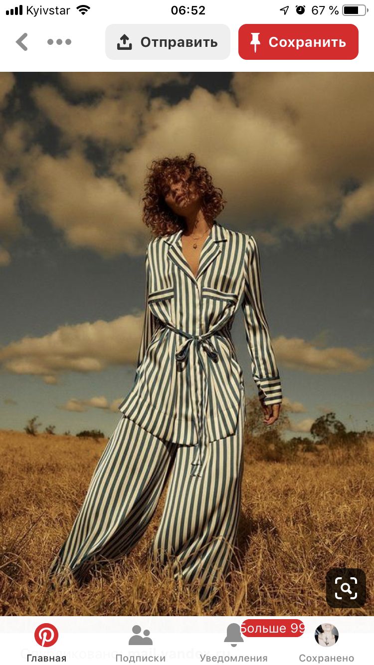 a woman standing in a field wearing a striped dress