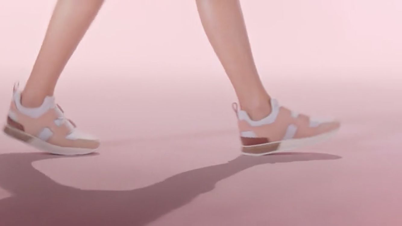 a woman's legs and shoes with a pink background