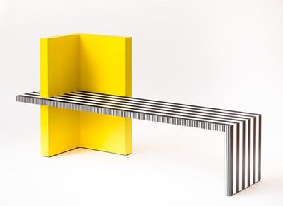 a bench made out of yellow and black strips