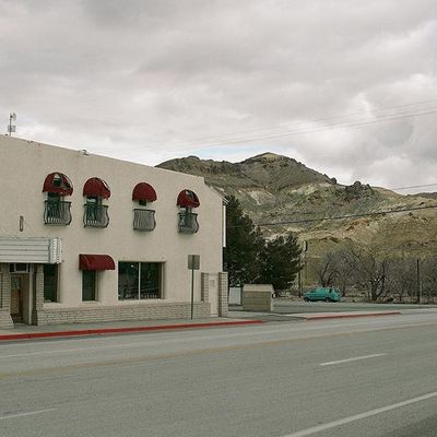 a white building with red awnings next to a street