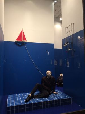 a mannequin sitting on a blue tiled floor