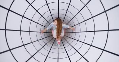 a little girl is standing in the middle of a circular structure