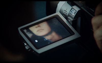 a person holding a camera with a picture of a woman on it