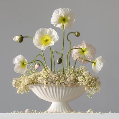 a white vase filled with flowers on top of a table