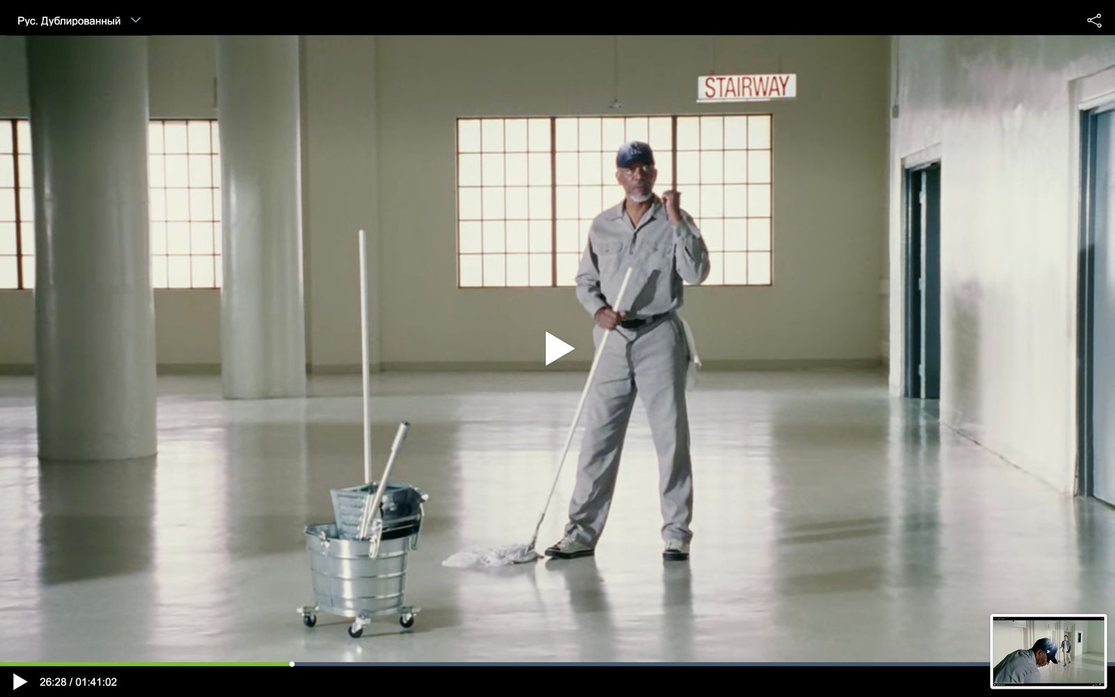 a man standing in a room with a mop