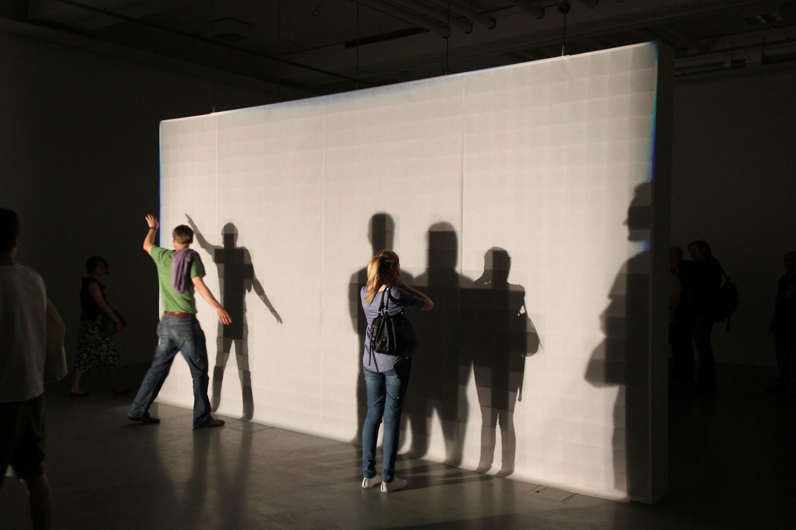 a group of people standing in front of a white wall