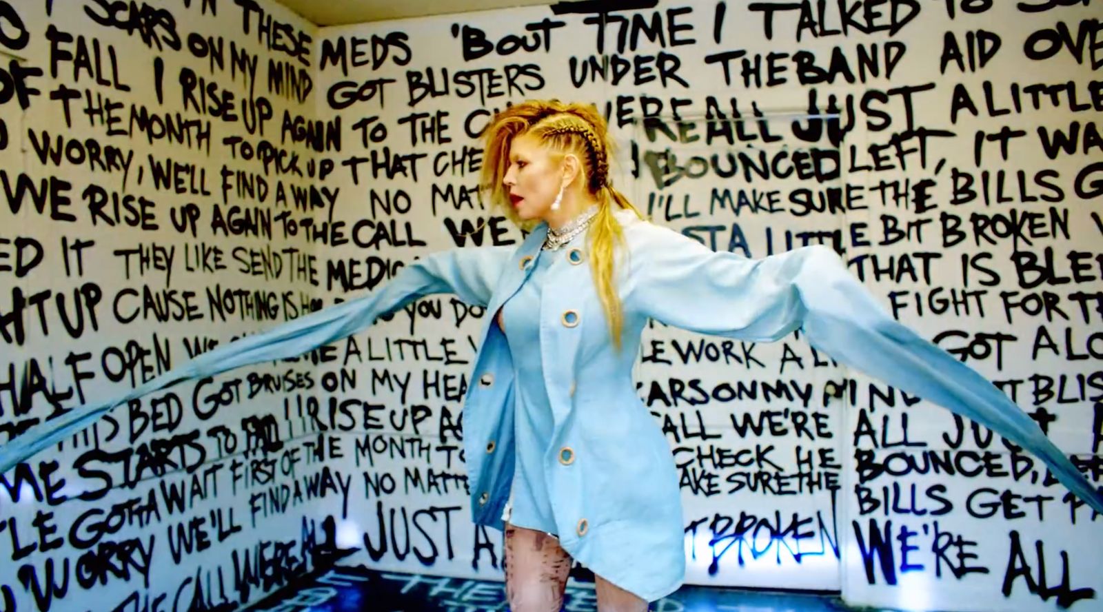 a woman standing in front of a wall with writing on it