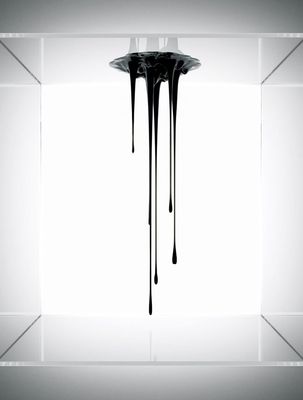 a black and white photo of a dripping vase