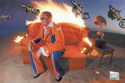 a man sitting on top of a couch in front of a fire