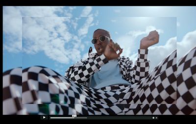 a man in a checkered jacket talking on a cell phone