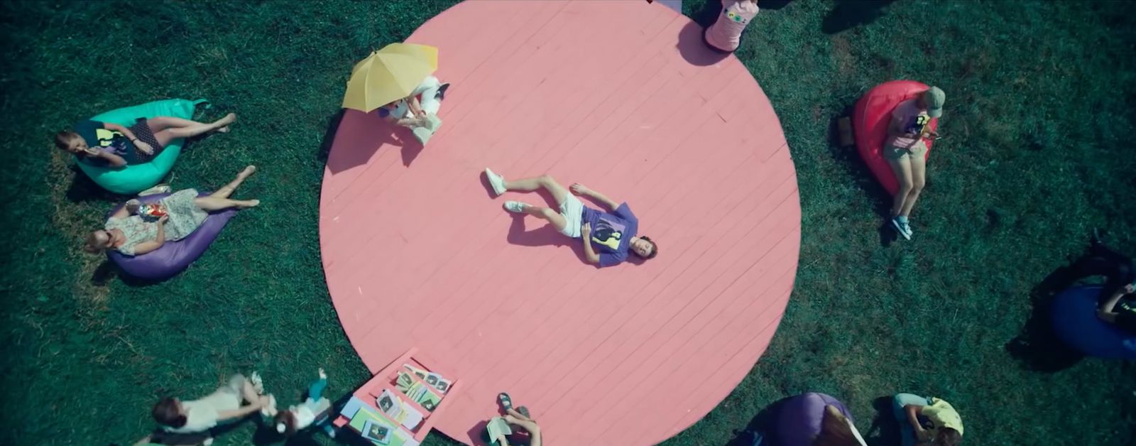 a group of people laying on bean bags in the grass