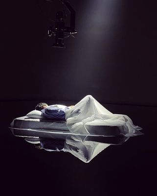 a person laying on a bed in a dark room