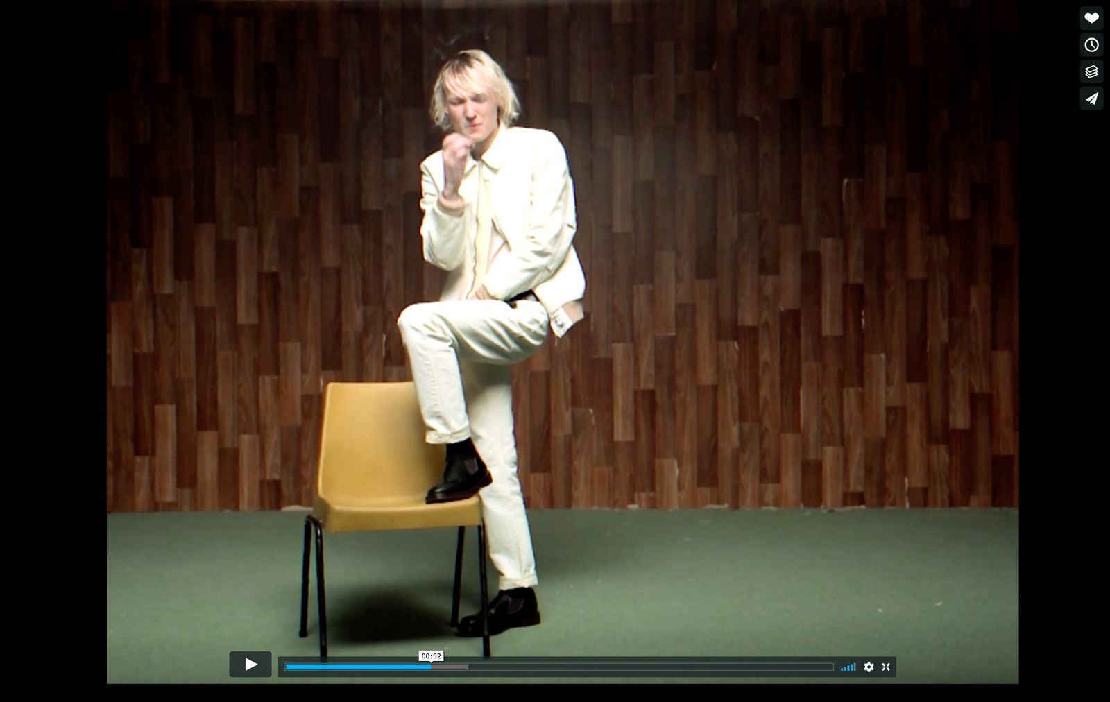 a man in a white suit sitting on a chair