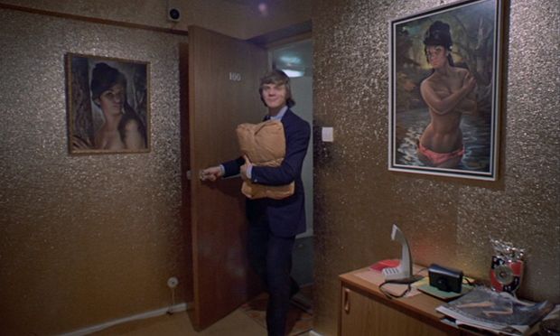 a woman is standing in a room with paintings on the wall