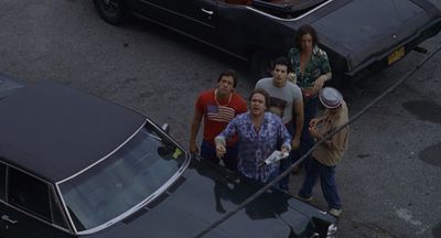 a group of people standing next to a black car