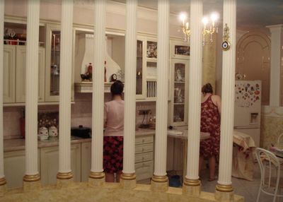 a woman in a red dress standing in a kitchen