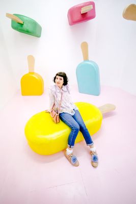 a woman sitting on top of a yellow bench