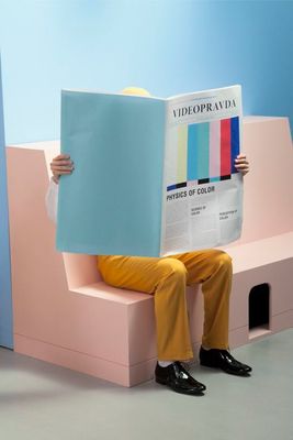 a man sitting on a bench reading a newspaper