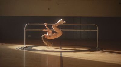 a woman doing a handstand on a metal pole