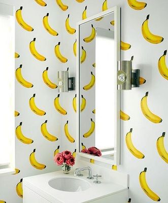 a bathroom with a sink, mirror and a bunch of bananas on the wall