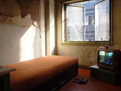 a bed room with a bed a tv and a window