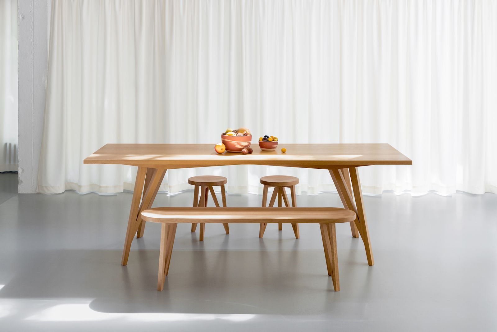 a wooden table with a bench and two stools