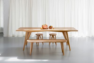 a wooden table with a bench and two stools