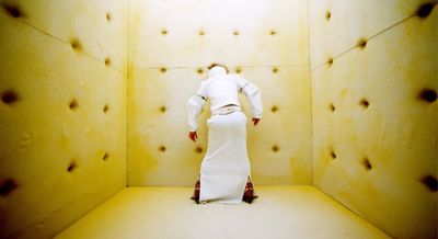 a woman in a white dress standing in a room