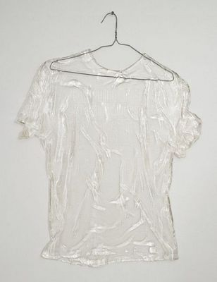 a white shirt hanging on a hanger