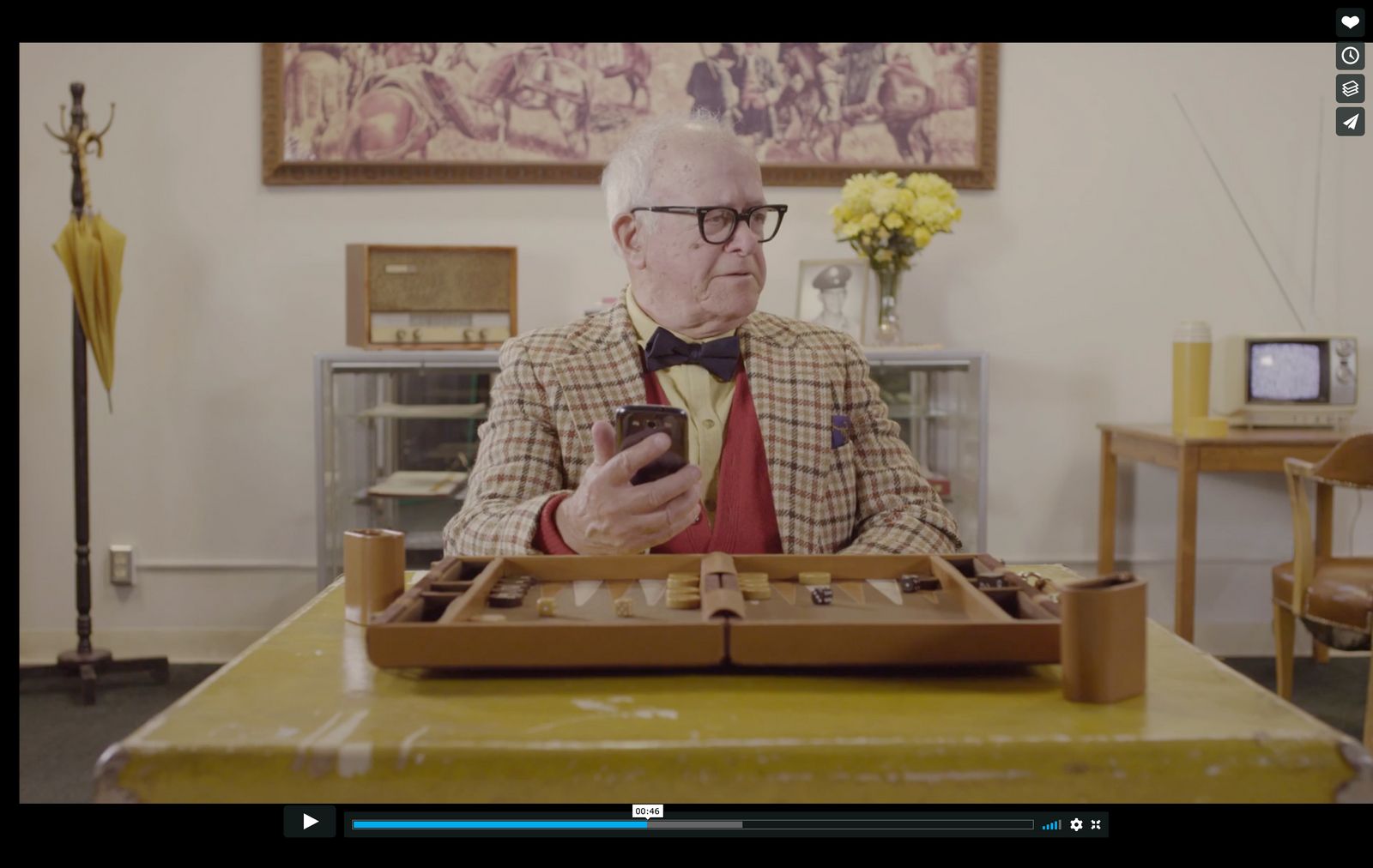 a man sitting at a table looking at a cell phone