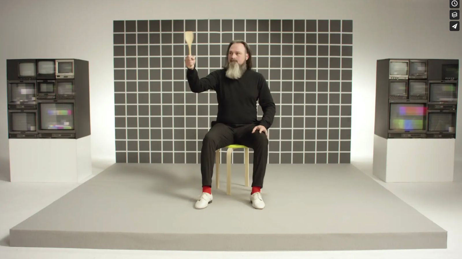 a man sitting on top of a chair in front of a wall