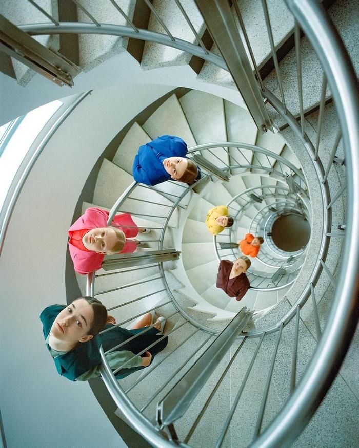 a group of people sitting on top of a spiral staircase