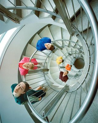 a group of people sitting on top of a spiral staircase