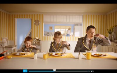 a man and two children sitting at a table eating food