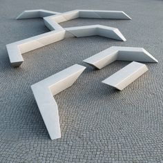 a set of curved concrete benches sitting on top of a stone floor