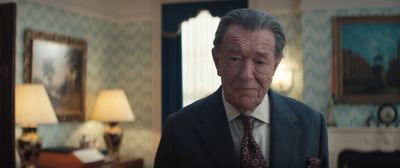 a man in a suit and tie standing in a living room